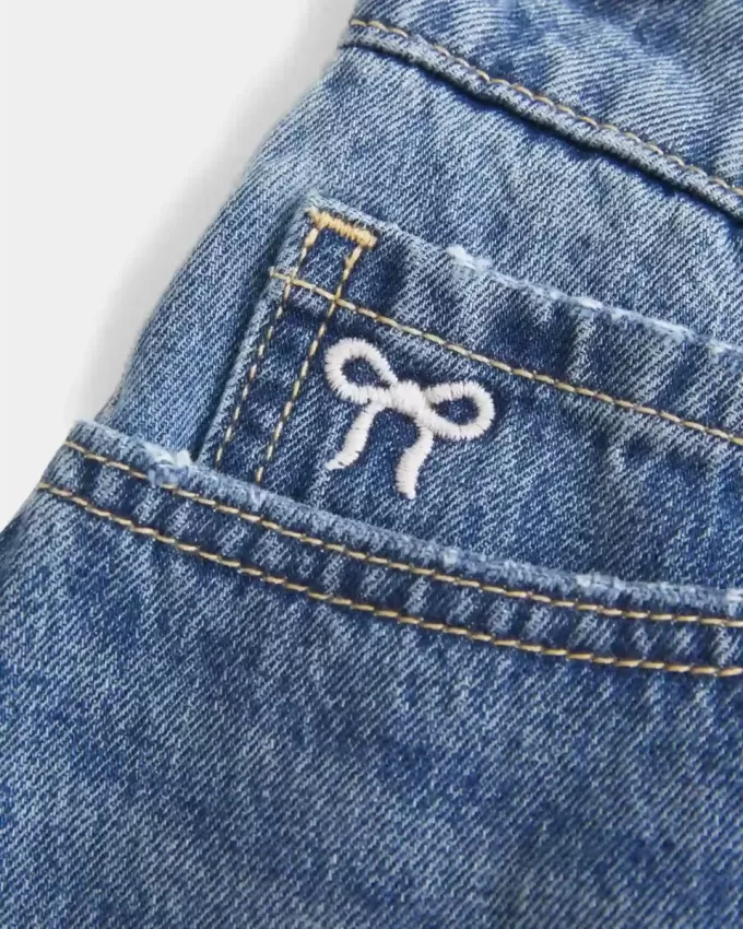 Curvy Low-Rise Mini-Jeansrock mit bestickter Schleife Curvy Low-Rise Mini-Jeansrock mit bestickter Schleife