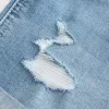 High-Rise Ripped Denim Shortie Shorts in mittlerer heller Waschung High-Rise Ripped Denim Shortie Shorts in mittlerer heller Waschung