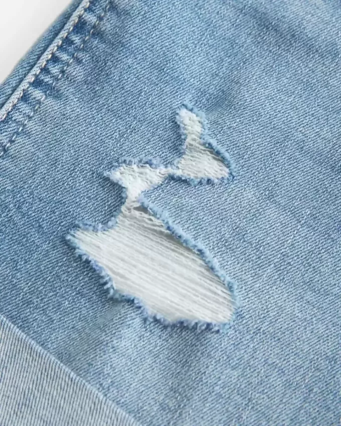 High-Rise Ripped Denim Shortie Shorts in mittlerer heller Waschung High-Rise Ripped Denim Shortie Shorts in mittlerer heller Waschung