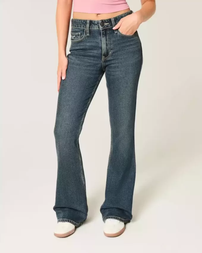 Hoch geschnittene Schlagjeans mit dunkler Waschung und Blumenstickerei Hoch geschnittene Schlagjeans mit dunkler Waschung und Blumenstickerei