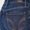 Hoch geschnittene, zerrissene Schlagjeans in dunkler Waschung
