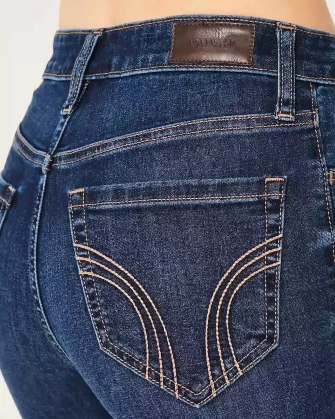 Hoch geschnittene, zerrissene Schlagjeans in dunkler Waschung