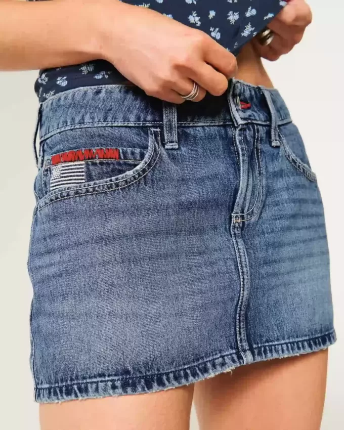 Low-Rise-Mini-Skort aus Denim mit mittlerer Waschung und Flaggenstickerei Low-Rise-Mini-Skort aus Denim mit mittlerer Waschung und Flaggenstickerei
