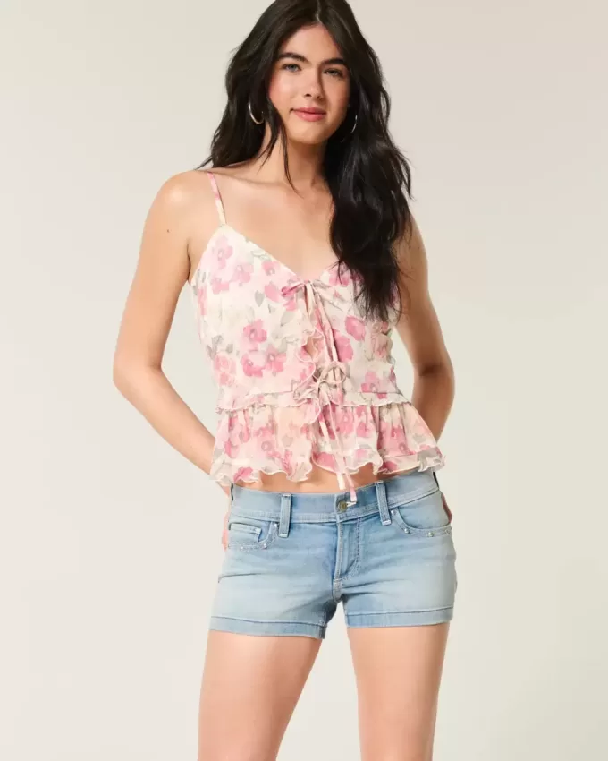 Low-Rise-Shortie-Shorts aus Denim mit mittlerer Waschung und Nieten Low-Rise-Shortie-Shorts aus Denim mit mittlerer Waschung und Nieten