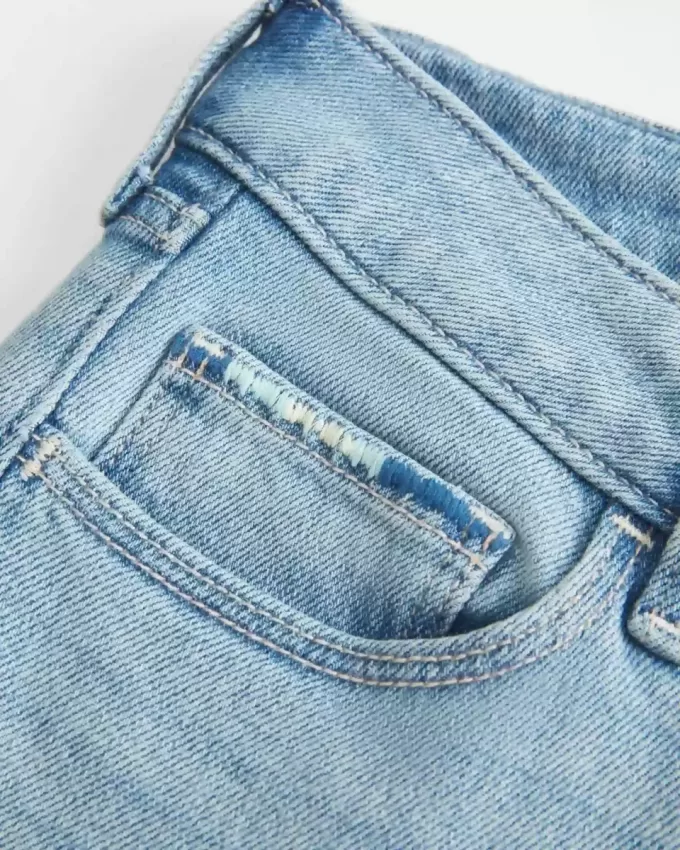 Niedrig geschnittene, zerrissene Bootcut-Jeans in heller Waschung mit Stickerei Niedrig geschnittene, zerrissene Bootcut-Jeans in heller Waschung mit Stickerei
