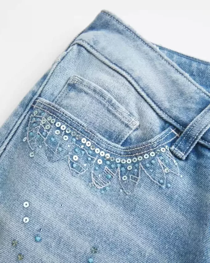 Ultra Low-Rise Distressed Light Wash Flare Jeans mit Pailletten
