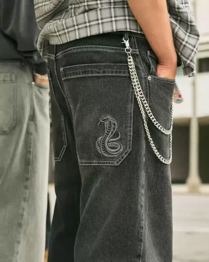 Verwaschene schwarze Skater-Baggy-Jeans mit Schlangenstickerei